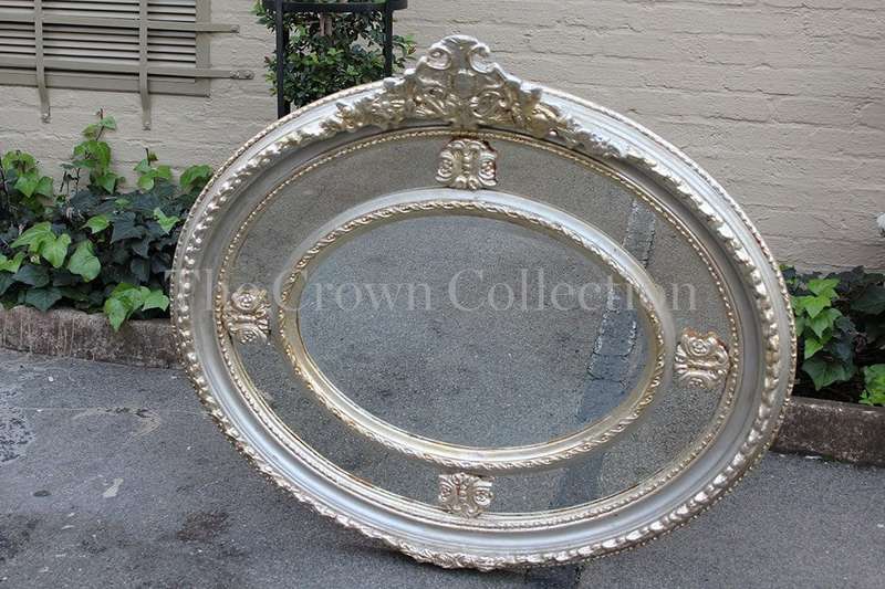 Ornate oval silver gilded mirror with crown