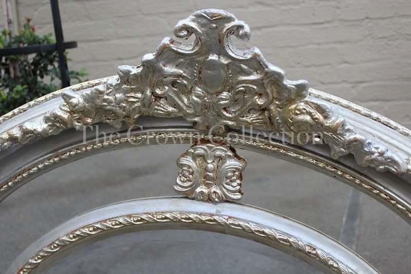 Ornate oval silver gilded mirror with crown