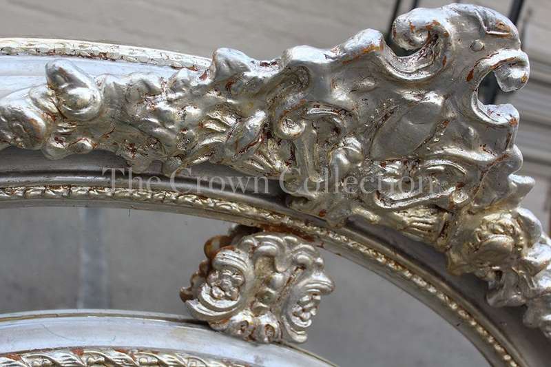Ornate oval silver gilded mirror with crown