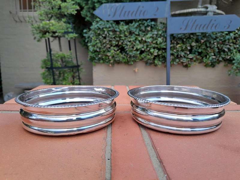 An Early 20th Century Pair of Silver plated Wine Bottle Coasters with Wooden Bases