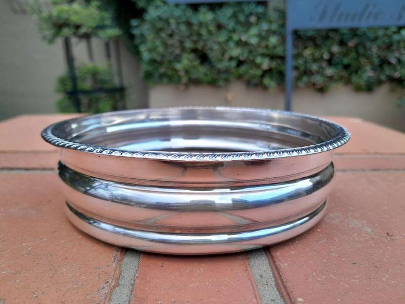 An Early 20th Century Pair of Silver plated Wine Bottle Coasters with Wooden Bases