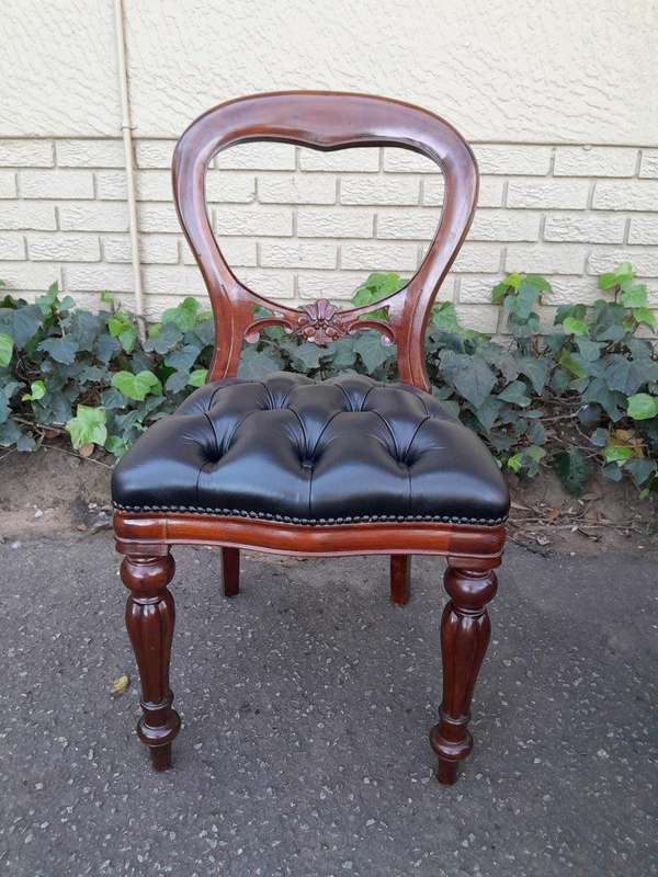 A 20th Century Set of Ten Teak Wood Bustle Back Chairs Upholstered in Deep Buttoned Leather