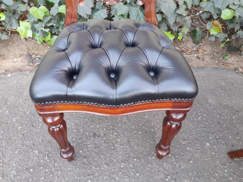A 20th Century Set of Ten Teak Wood Bustle Back Chairs Upholstered in Deep Buttoned Leather