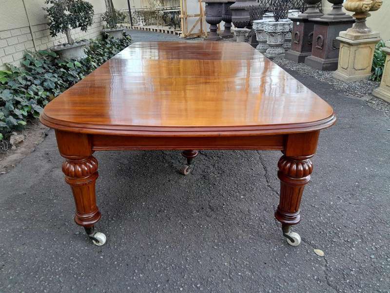 An Antique Victorian Oak Dining Table on Porcelain Castors with Two Leaves