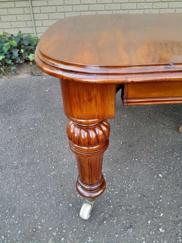 An Antique Victorian Oak Dining Table on Porcelain Castors with Two Leaves