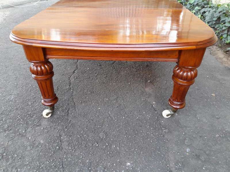 An Antique Victorian Oak Dining Table on Porcelain Castors with Two Leaves