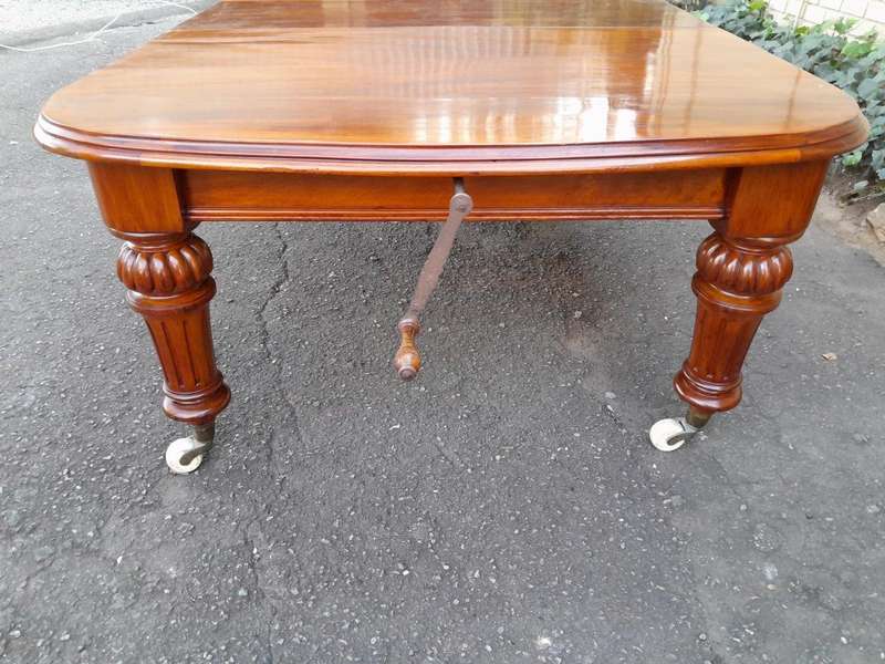 An Antique Victorian Oak Dining Table on Porcelain Castors with Two Leaves