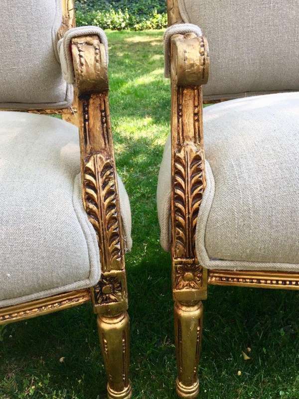 A Pair of French Louis XVI Styled Ornately carved and gilded Fautelli  Chairs in Linen Upholstery
