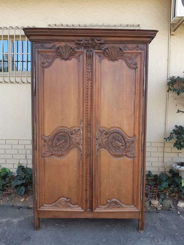 A French Provincial styled Ornately carved Armoire