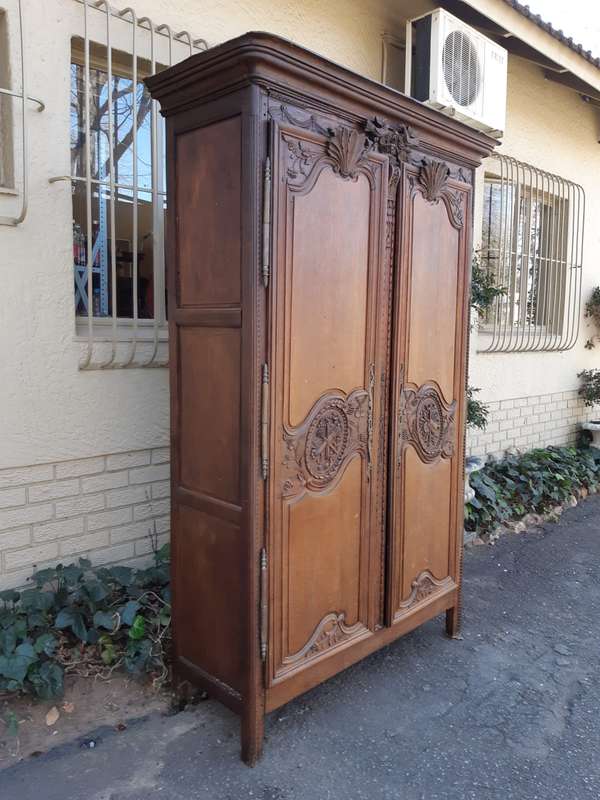 A French Provincial styled Ornately carved Armoire