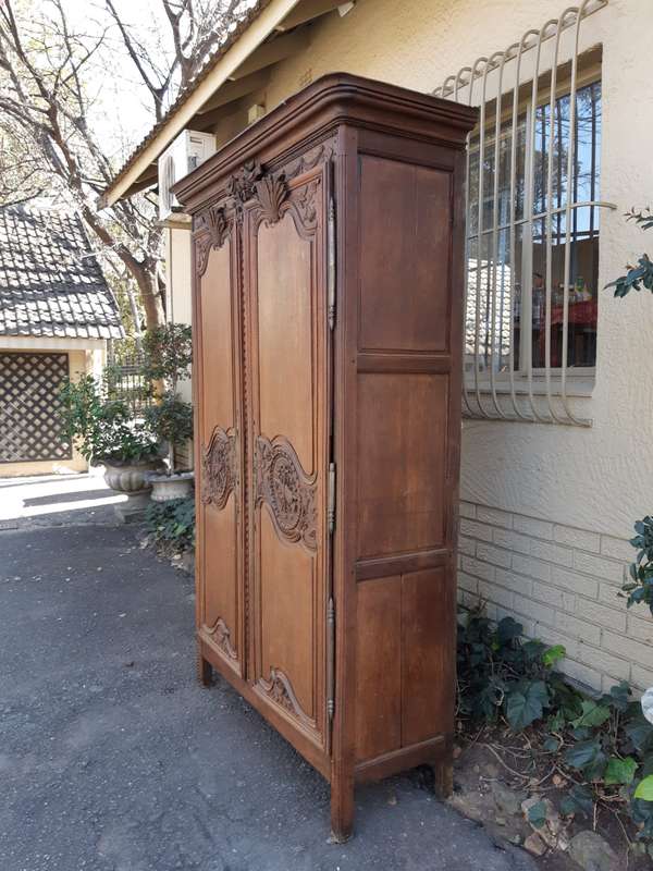 A French Provincial styled Ornately carved Armoire