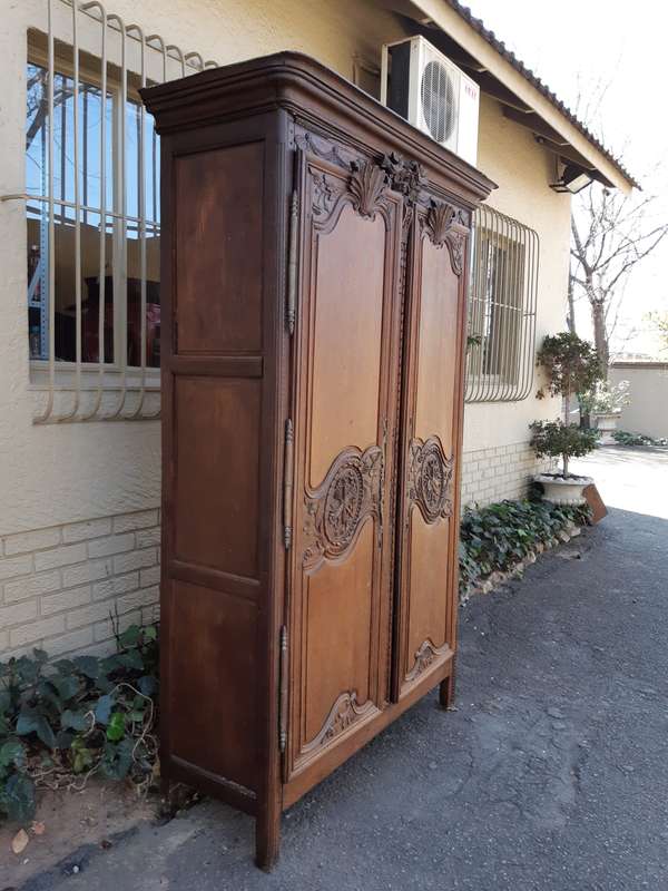 A French Provincial styled Ornately carved Armoire