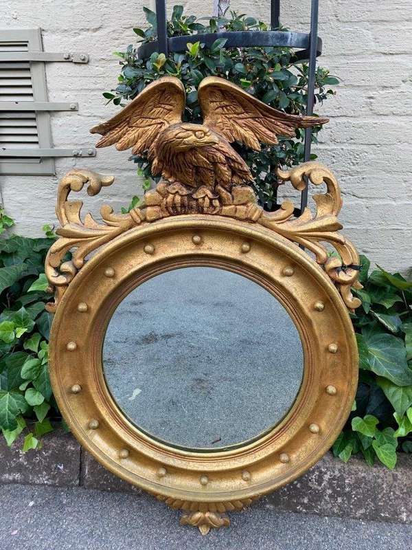 A circular framed 19thC style mirror with eagle crest