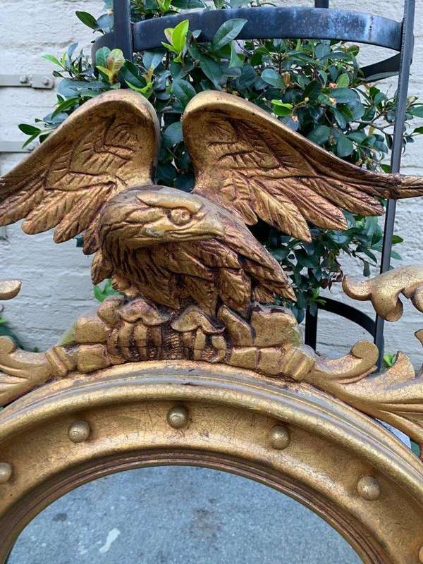 A circular framed 19thC style mirror with eagle crest