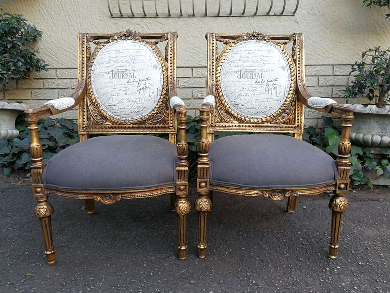 An Exceptional Pair of French Style Carved and Gilded Armchairs Upholstered in a Custom-Made Line...