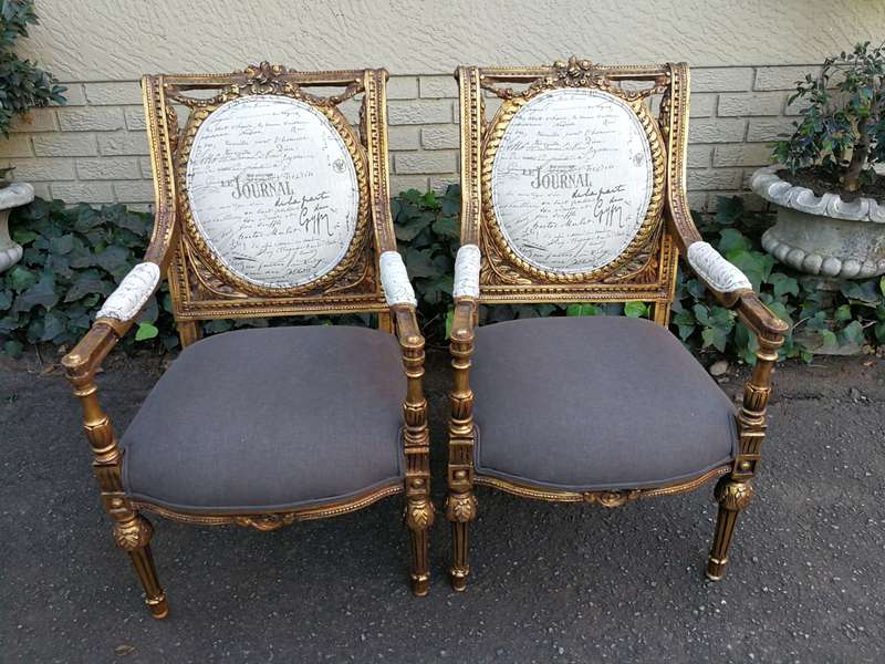 An Exceptional Pair of French Style Carved and Gilded Armchairs Upholstered in a Custom-Made Line...