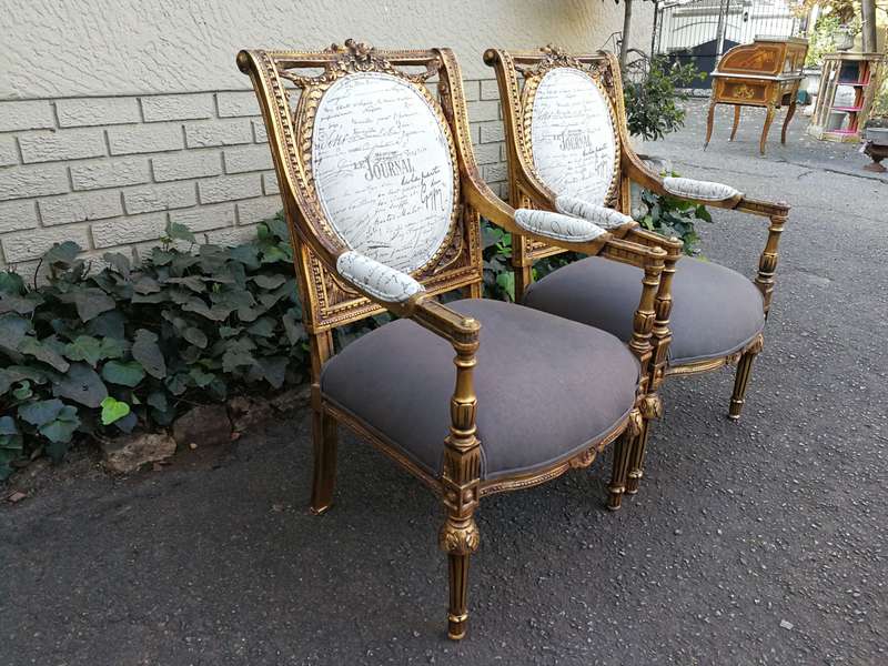 An Exceptional Pair of French Style Carved and Gilded Armchairs Upholstered in a Custom-Made Line...