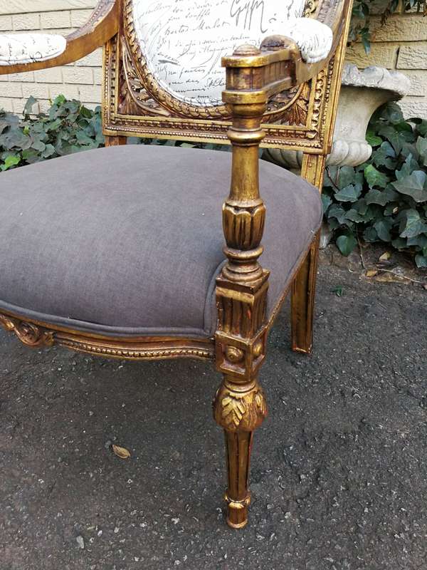 An Exceptional Pair of French Style Carved and Gilded Armchairs Upholstered in a Custom-Made Line...