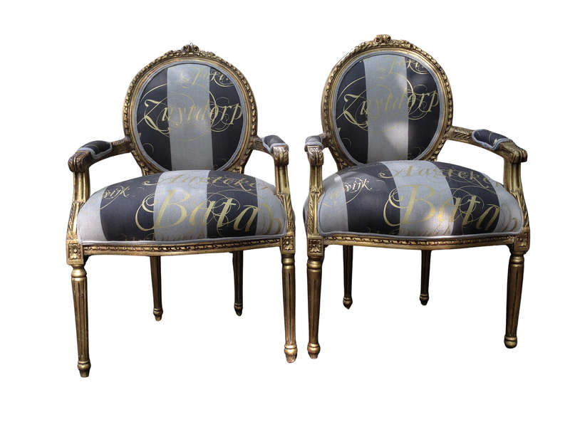 A Pair of French Style Arm Chairs Hand Gilded With Gold Leaf And Upholstered In an Imported Scrip...