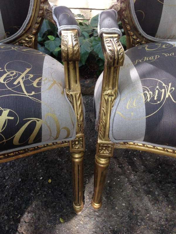 A Pair of French Style Arm Chairs Hand Gilded With Gold Leaf And Upholstered In an Imported Scrip...