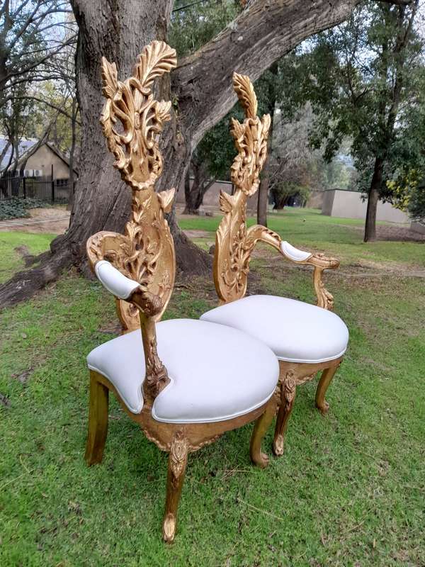 A Pair of Baroque Style Carved and Hand Gilded High Back Throne Chairs (upholstered in white)