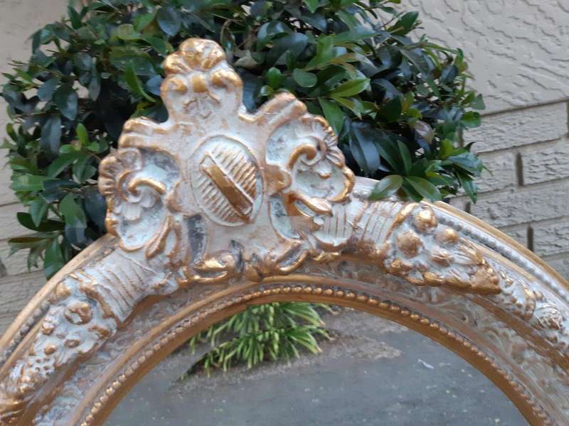 An Oval Ornate Bevelled Mirror