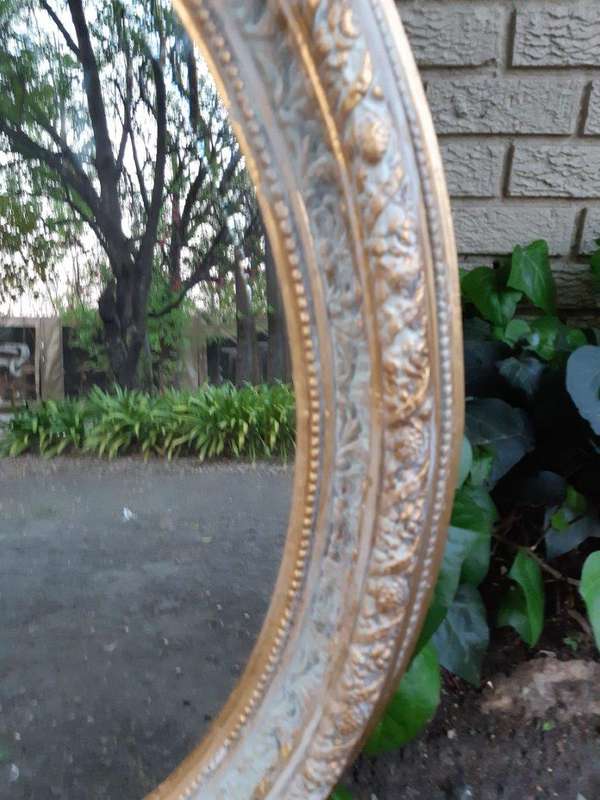 An Oval Ornate Bevelled Mirror