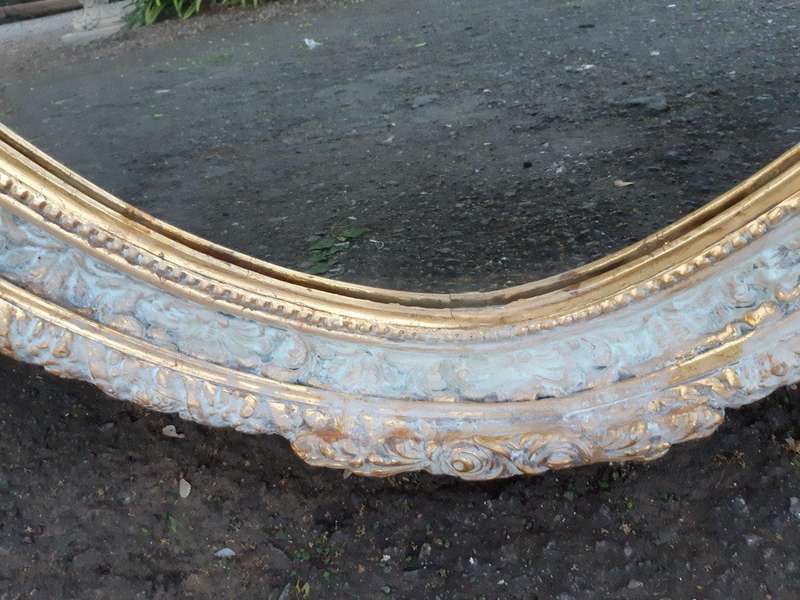 An Oval Ornate Bevelled Mirror