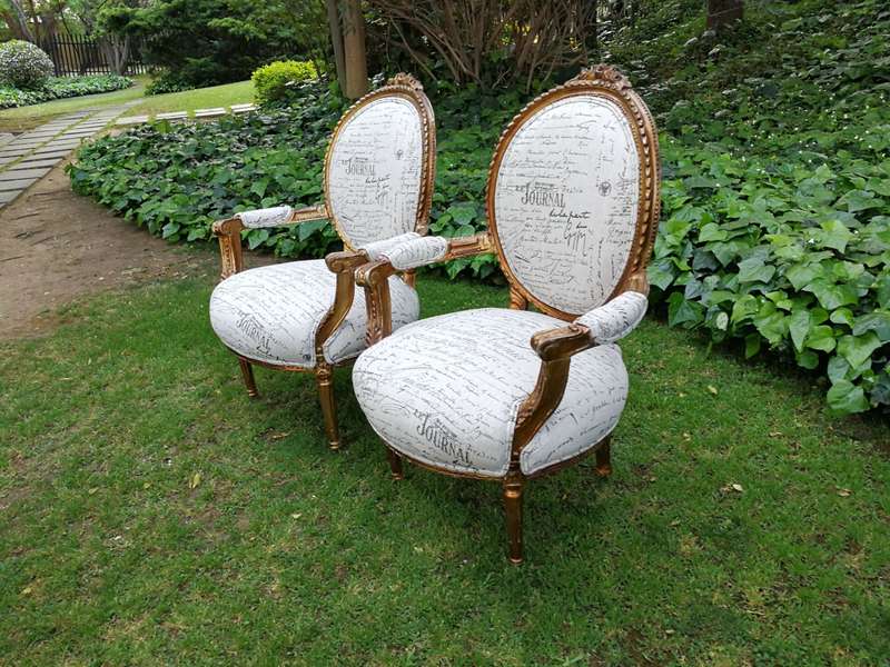 A Pair of French Style Carved and Gilded Armchairs Upholstered in a Custom-made Script on Linen F...