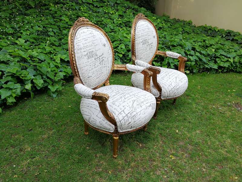 A Pair of French Style Carved and Gilded Armchairs Upholstered in a Custom-made Script on Linen F...