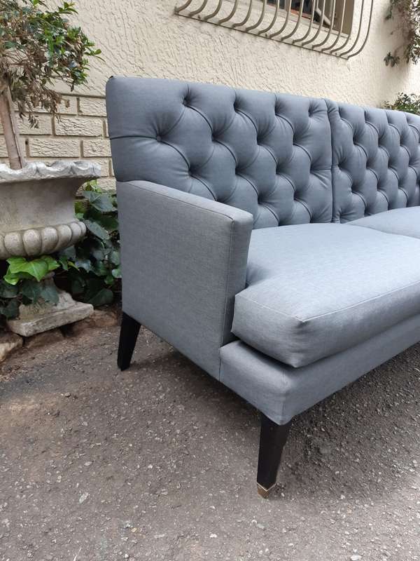 A Designer Sofa in a Grey Imported Waterproof and Stain Resistant Fabric. Condition is as new.