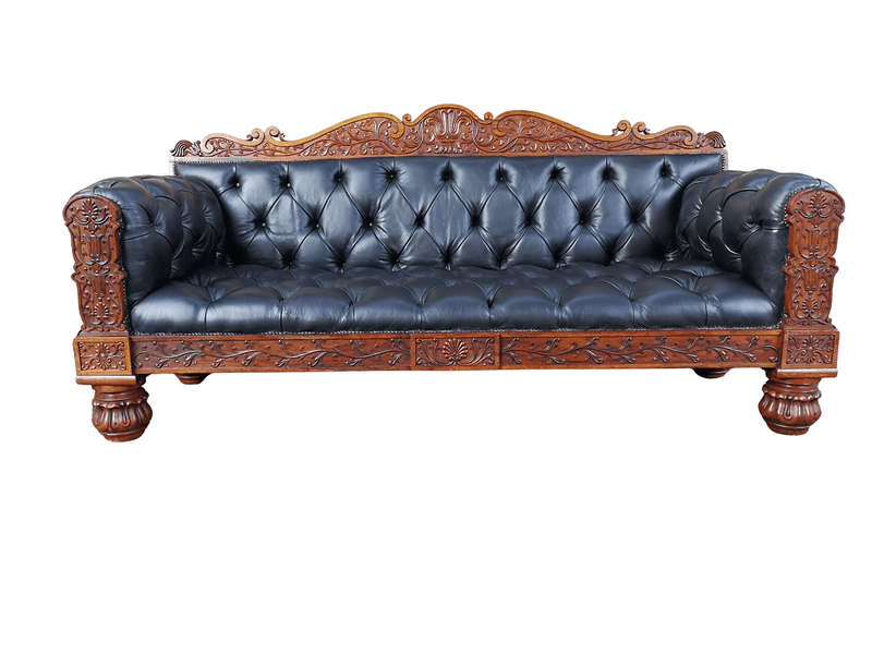 An Anglo Indian Carved Rosewood and Teak settee with brass castors