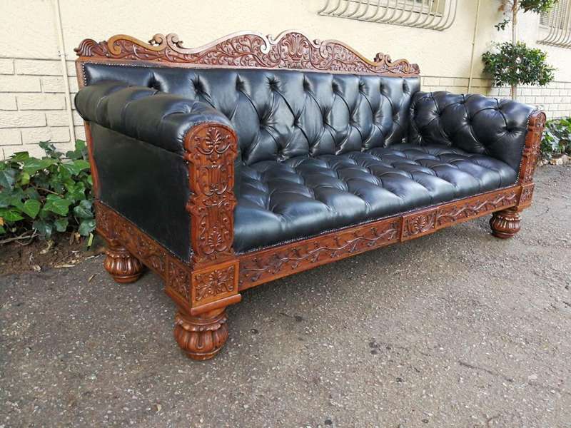 An Anglo Indian Carved Rosewood and Teak settee with brass castors