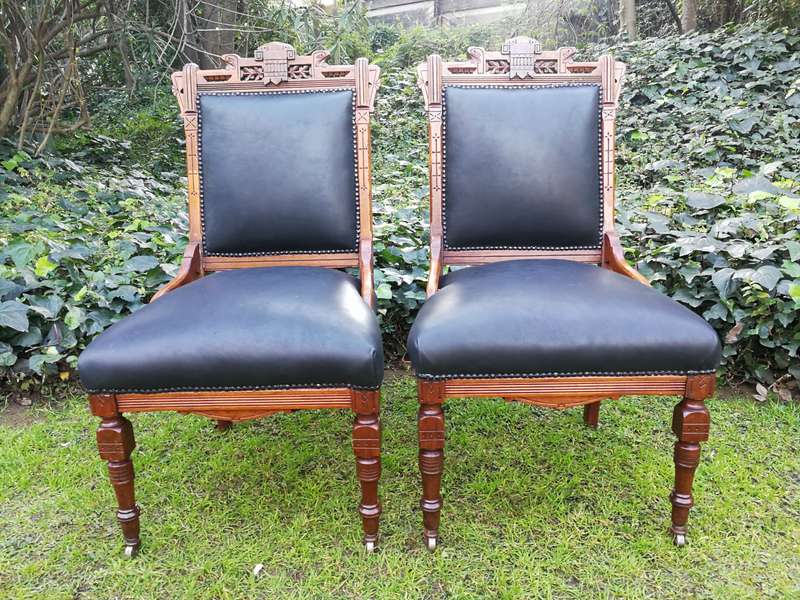 A Late 19th Century Pair of Victorian Carved Walnut Chairs Upholstered in Leather on Casters