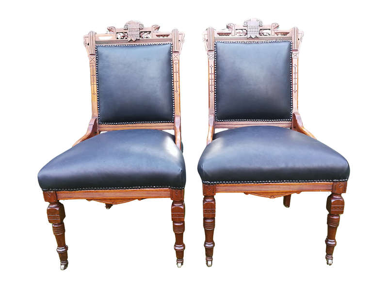 A Late 19th Century Pair of Victorian Carved Walnut Chairs Upholstered in Leather on Casters