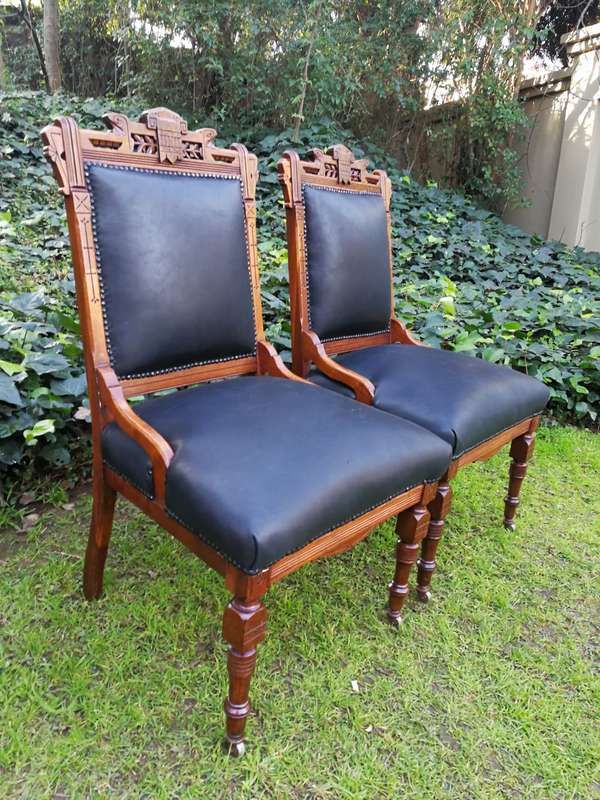 A Late 19th Century Pair of Victorian Carved Walnut Chairs Upholstered in Leather on Casters