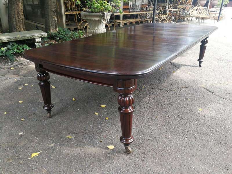 A three meter Victorian mahogany extending dining table on carved legs and castors, with four lea...