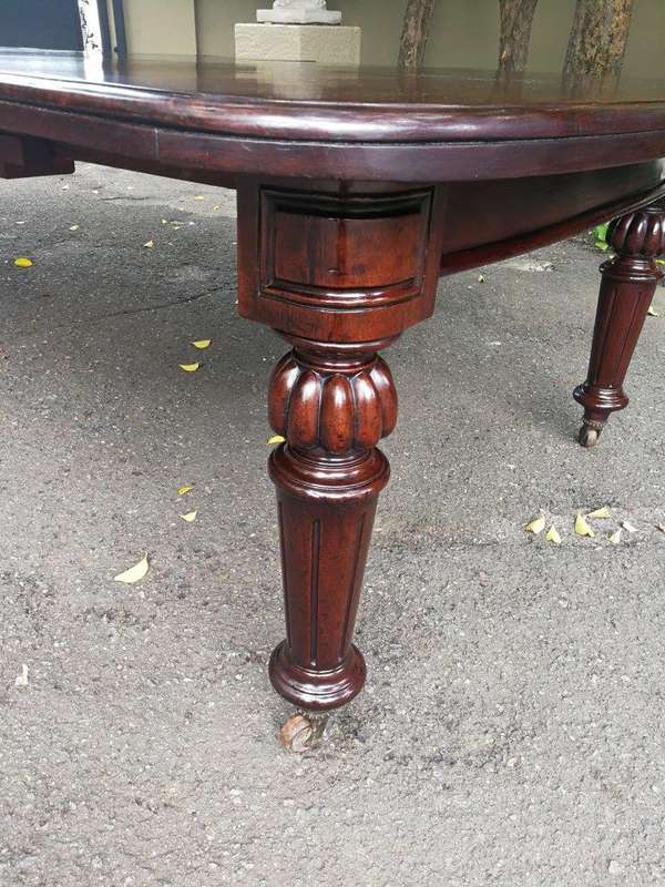 A three meter Victorian mahogany extending dining table on carved legs and castors, with four lea...