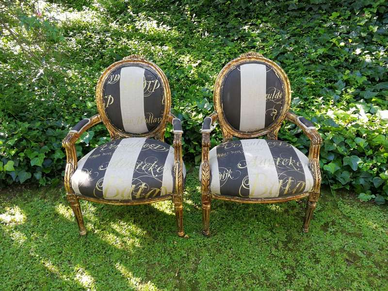 A Pair of French Style Arm Chairs Hand Gilded With Gold Leaf And Upholstered In an Imported Scrip...