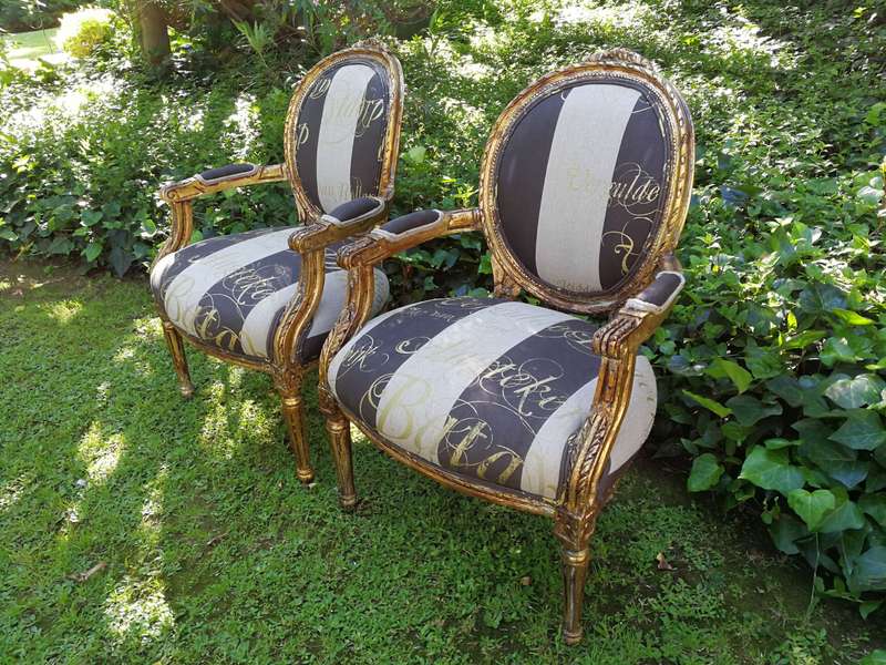 A Pair of French Style Arm Chairs Hand Gilded With Gold Leaf And Upholstered In an Imported Scrip...