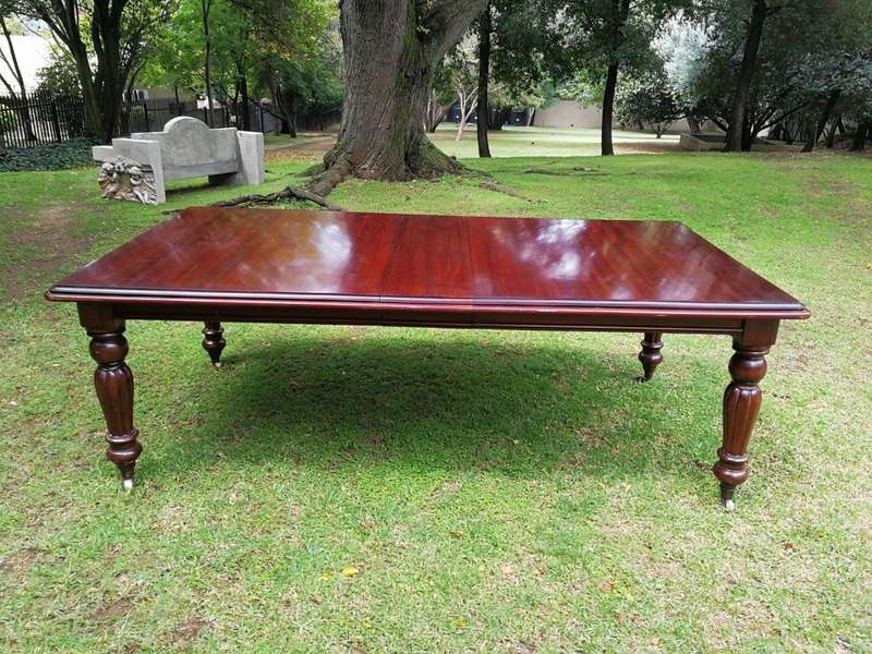 A Victorian Style Mahogany extending ten-seater dining room table on brass castors and with windi...