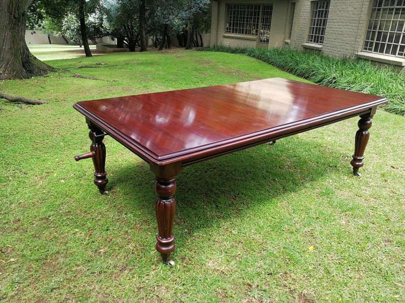 A Victorian Style Mahogany extending ten-seater dining room table on brass castors and with windi...