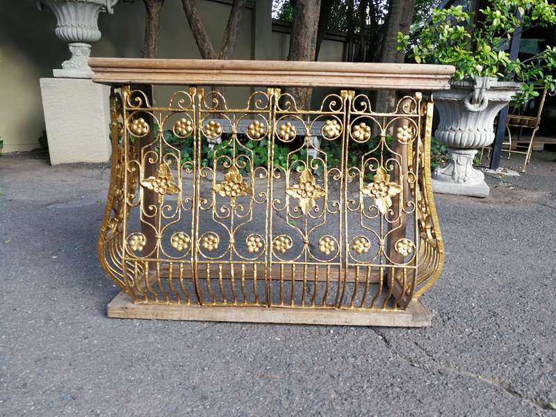 A wooden and marble-topped cast-iron console table
