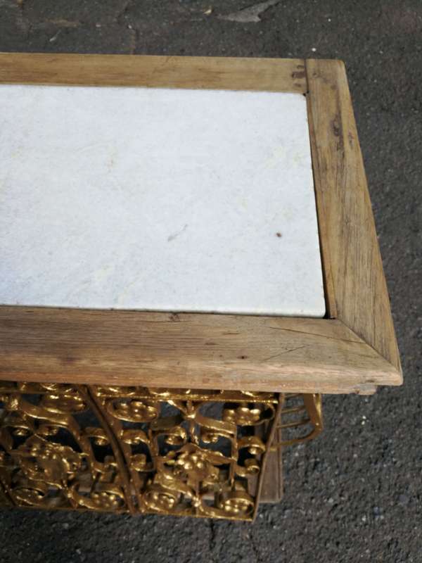 A wooden and marble-topped cast-iron console table