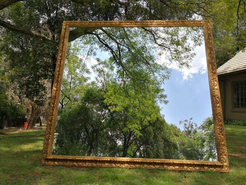 A large gilded mirror with ornate frame