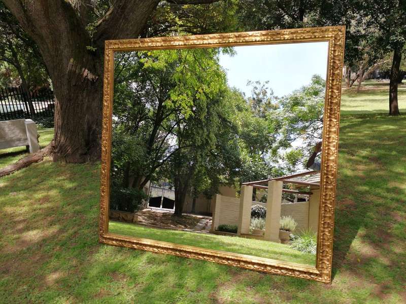 A large gilded mirror with ornate frame