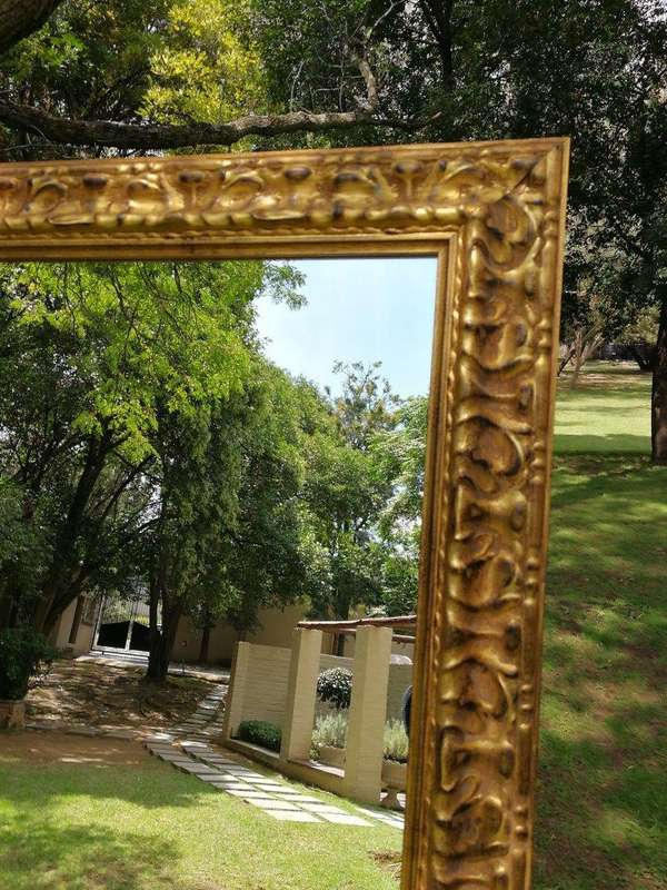 A large gilded mirror with ornate frame