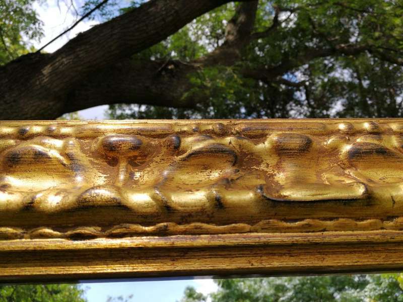 A large gilded mirror with ornate frame