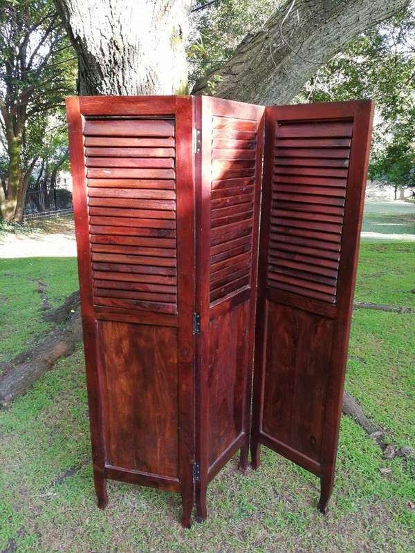 A 20th century Mahogany three-panel folding floor screen, with adjustable louvered panels