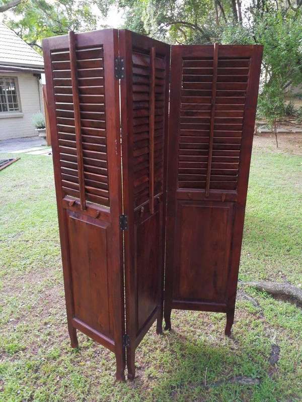 A 20th century Mahogany three-panel folding floor screen, with adjustable louvered panels